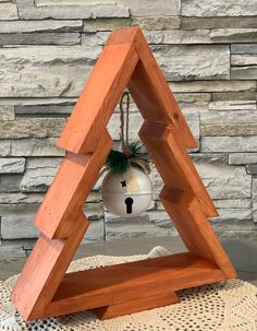 a wooden triangle with a bell hanging from it