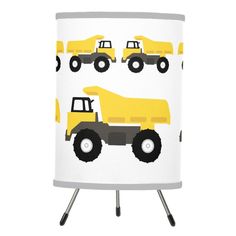 a yellow and black lamp shade with trucks on the front, in grey and white