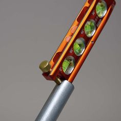 an orange and silver toothbrush with several different colored buttons on it