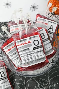 three packages of blood sitting on top of a table next to spider webs and halloween decorations