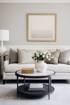 a living room filled with furniture and a painting on the wall above it's coffee table