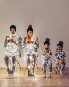 three people in silver pajamas sitting next to each other