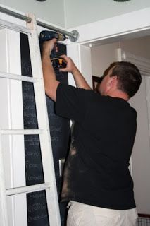 a man climbing up the side of a ladder to install a light fixture on a wall