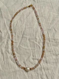 Enhance your style with this stunning 16-inch beaded necklace, meticulously handcrafted to bring a touch of elegance to any outfit. The necklace features high-quality beads, arranged in a delicate pattern, and is finished with a durable silver-plated clasp that ensures a secure and comfortable fit. Perfect for special occasions or everyday wear, this beaded necklace adds a sophisticated flair to your jewelry collection. Whether you're dressing up for a formal event or looking to add a touch of glamour to your casual ensemble, this versatile necklace is the ideal accessory. Key Features: Length: 16 inches Material: High-quality beads Clasp: Gold-plated, secure fit Handmade with care Ideal for gifting on birthdays, anniversaries, or holidays Please note that this item is one-of-a-kind and ha Colorful Pearl Beaded Choker Necklace, Pearl Choker With Colorful Beads For Gifts, Pearl Choker With Colorful Round Beads, Handmade Pearl Beaded Choker Necklace, Handmade Pearl Beaded Necklace For Gift, Pearl Choker With Round Beads, Pearl Round Beads For Gifts, Pearl White Necklaces With Beaded Chain And Round Beads, Pearl White Necklaces With Beaded Chain