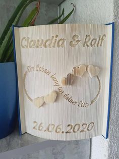 a wedding card with two hearts and the words claudia & rafh on it next to a potted plant