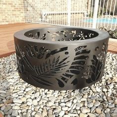 an outdoor fire pit surrounded by rocks and gravel