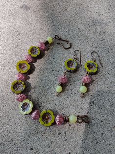 "Czech glass beads are the stars of this bead bracelet and drop earring set. The avocado hibiscus flowers are coin shaped, while the desert rose with copper lines are bicones. Olive New Jade (Quartz) rounds are at the ends with antique brass heishi. I used a natural antique brass hook and eye for the closure. The simple ear wires are also antique brass, as well as the wire used. The bracelet is 7 1/2\" long. The drop earrings are 2 1/4\" long." Czech Beads Bracelet, Czech Beads Jewelry, Czech Glass Jewelry, Easy Diy Jewelry, Floral Bracelet, Homemade Jewelry, Bracelets Handmade Beaded, Handcrafted Earrings, Christmas Jewelry