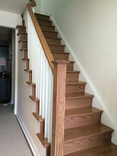 a wooden staircase with white handrails in a home's entryway area