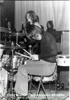 an old black and white photo of some people playing drums