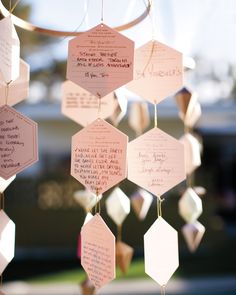 a close up of a wind chime with paper hanging from it's sides