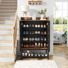 there are many pairs of shoes on the shelf in this living room with white walls and hardwood floors