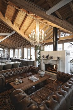 a living room filled with lots of furniture and a chandelier hanging from the ceiling