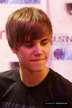 a young man with blonde hair and a black shirt