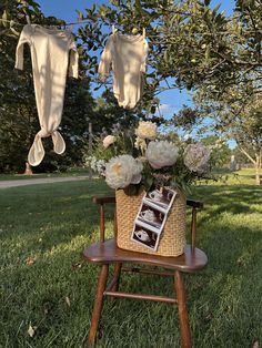 an old wooden chair with flowers and clothes hanging from it's clothesline in the grass