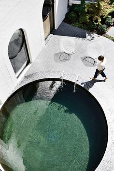 an aerial view of a person walking near a water fountain