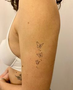 a woman with a butterfly tattoo on her left arm and right arm behind her back