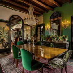 a dining room with green chairs and a chandelier