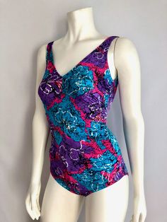 "Vintage Swimwear, Women's 80's Multi-Color One Piece, Swimsuit by Max of Hollywood (XS/S) This Ladies 80's swimsuit comes in a textured cotton/lycra blend and is all one piece with a scoop back. *The mannequin is a size 4 and this is too tight for her. 87% Nylon 13% Spandex Made in USA *This swimsuit is in excellent condition Size: (XS/S) Fits a modern day 2 (Tag Size: 10) Bust: up to 34\" Waist: 20\"-25\" Hips: 28\"-32\" Total Length: 27\" Strap Length: 12\"-13\" Weight: 9 oz *Follow FreshandS Pink Fitted Lined Tankini, Fitted Pink Lined Tankini, Fitted Purple Swimwear For Poolside, Purple One-piece Tankini For Poolside, Pink Fitted Leotard For Swimming, Fitted Pink Leotard For Swimming, Pink Retro Stretch Swimwear, Summer Swimming Bodysuit In Purple, Summer Purple Swimming Bodysuit