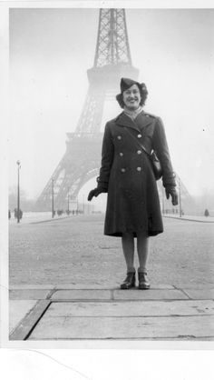 an old photo of a woman in front of the eiffel tower, paris