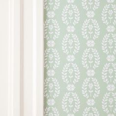 the wall paper is green and white with leaves on it, as well as a door handle