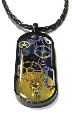 a necklace with a clock on it and gears attached to the back of its pendant