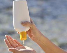 a person holding a bottle with liquid in it and another hand reaching out towards the water