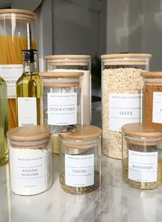 several jars with labels on them sitting on a counter next to pasta noodles and other items