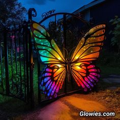 a colorful butterfly light up gate at night