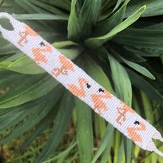 an orange and white beaded keychain with cats on it's side