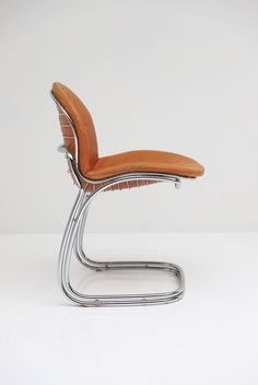 an orange leather chair with chrome frame and foot rest on a white surface, viewed from the front