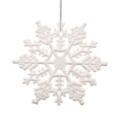 a white snowflake ornament hanging from a string on a white background