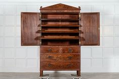 an old wooden cabinet with two drawers and wheels on the bottom, in front of a white brick wall