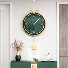 a green and gold clock mounted on the wall above a cabinet with flowers in vases