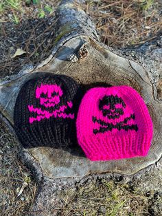 two knitted hats sitting on top of a tree stump