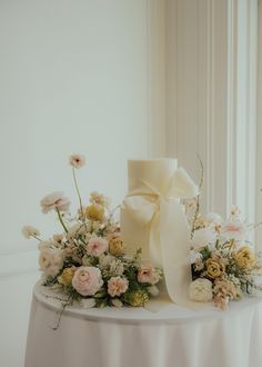 a table with flowers and a white bow on it