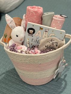 a basket filled with lots of different items on top of a blue table covered in pink and white