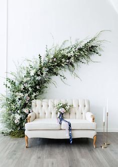 a couch with flowers and greenery on it