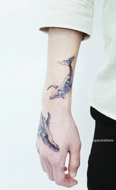 a person with a whale tattoo on their arm