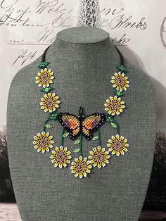 a necklace with sunflowers and butterflies on it