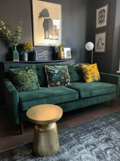 a living room filled with green couches and colorful pillows on top of it's covers