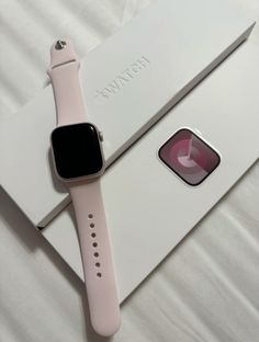 an apple watch sitting on top of a white box next to a pink apple watch