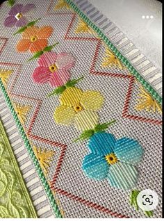 some flowers are on the side of a piece of fabric that has been stitched together