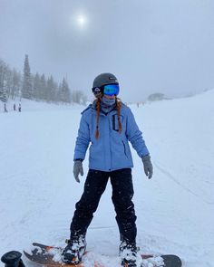 a person standing on a snowboard in the snow with skis and goggles