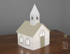 a paper model of a church on a wooden table with the words svg cut file below it