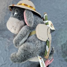 a stuffed animal is wearing a hat and holding it's back in the water