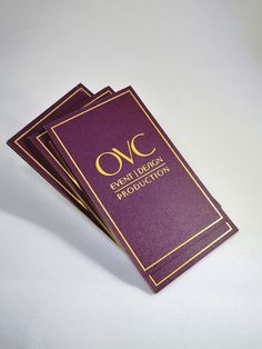 three purple and gold business cards with the words oc on them sitting next to each other