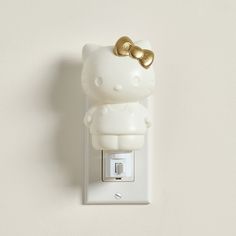 a hello kitty light switch cover with a gold bow