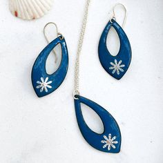 In the spirit of the holidays, the ocean lover can still wear blue and be festive. This lovely tear drop shaped necklace and earring set has a striking blue enamel with a little silver foil snowflake fired into the tip. They are a perfect size, not too big, not too small. Perfect for a festive outfit. I give you a special 15% discount for purchasing the set. Pendant and earrings: Height: 1 5/8" Width: 3/4" at widest point Necklace comes with silver plated cable chain 16 " with 2 " extender. Ster Enameling Jewelry, Copper Jewellery, Snowflake Necklace, Silver Snowflakes, Ocean Lover, Necklace And Earring Set, Enamel Earrings, Polymer Clay Art, Enamel Jewelry