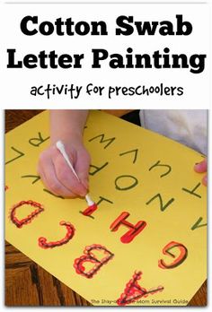 a child's hand is writing on a yellow paper with the words cotton swab letter painting