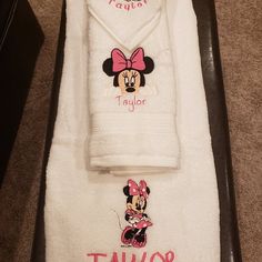 a towel with minnie mouse on it and the word taylor written in pink is next to a mickey mouse bathrobe